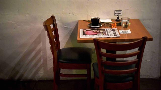 Una taza de café, agua y el diario con la historia de su muerte en la mesa del café que frecuentaba Javier, el 16 de mayo de 2017