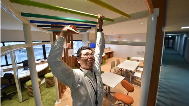 Un empleado de la empresa de fabricación de equipos eléctricos con sede en Tokio, Fujikura, mientras hace ejercicios en la sala de actividades de salud de la compañía.