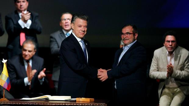 Santos y "Timochenko" se saludan tras la firma del acuerdo en Bogotá